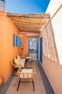 a balcony with tables and chairs on a wall at SUN PETRADI Tradition & Luxury in Koskinou