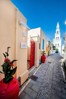 a street with a red door and a building at SUN PETRADI Tradition & Luxury in Koskinou