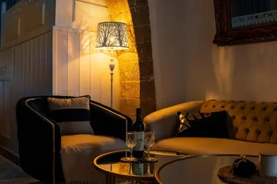 a living room with a couch and a table and a lamp at SUN PETRADI Tradition & Luxury in Koskinou