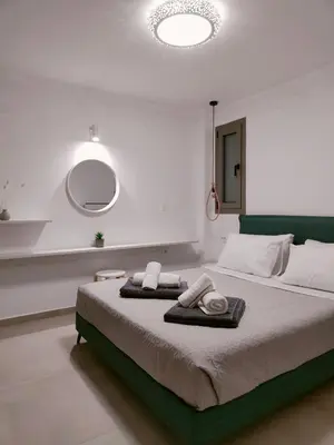 a bedroom with a large bed with towels on it at Alpha Villas in Gennadi