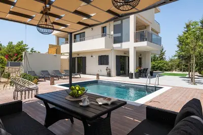 a villa with a swimming pool and a house at Dioni Pool House in Ialyssos