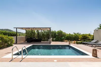 a swimming pool in a backyard with a pergola at Dioni Pool House in Ialyssos