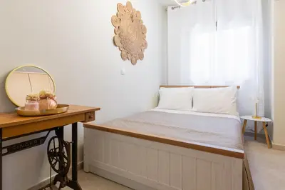 a bed in a room with a mirror and a table at Dioni Pool House in Ialyssos