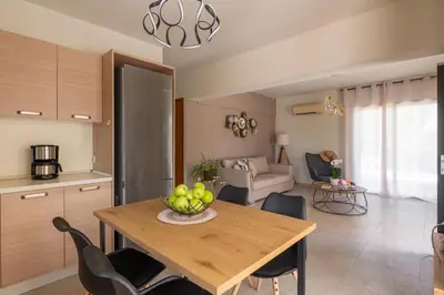a kitchen and dining room with a table and chairs at Dioni Pool House in Ialyssos