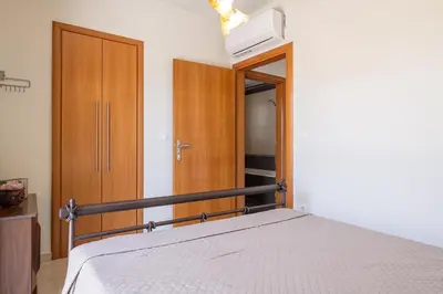 a bedroom with a bed and a wooden closet at Dioni Pool House in Ialyssos