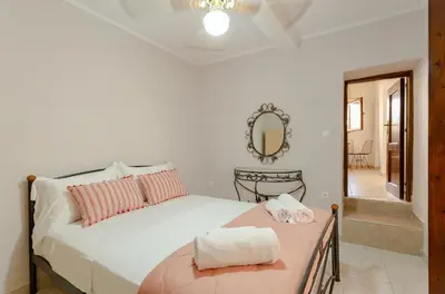 a bedroom with a white bed and a mirror at Evaxenia's House Old Town Rhodes in Rhodes Town