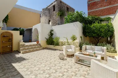 an outdoor patio with white furniture and plants at Evaxenia's House Old Town Rhodes in Rhodes Town