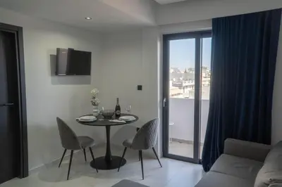 a living room with a table and chairs and a couch at Aegean Stars in Rhodes Town