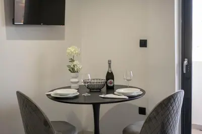 a dining room table with a bottle of wine and chairs at Aegean Stars in Rhodes Town