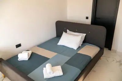 a bed in a room with towels on it at Aegean Stars in Rhodes Town