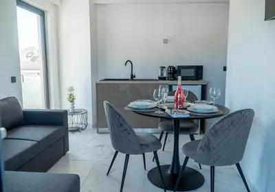 a dining room with a table and chairs and a kitchen at Aegean Stars in Rhodes Town