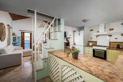 a kitchen with a staircase and a living room at Petalo House in Symi