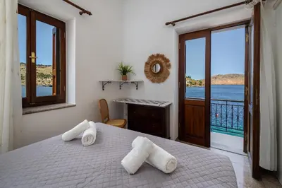 a bedroom with a bed and a view of the ocean at Petalo House in Symi
