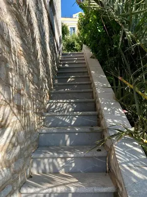 a stairway leading up to a stone wall at Petalo House in Symi