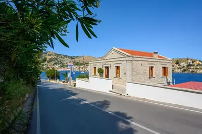 a street with a building on the side of a road at Petalo House in Symi
