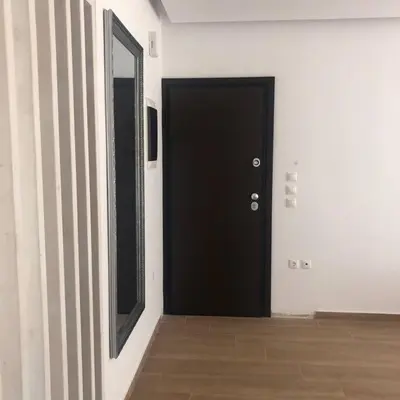 a black door in a white room with a wooden floor at Appartement in Rhodos Stadt in Rhodes Town