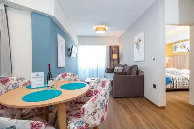 a room with a table and chairs and a bedroom at Sunny Days Hotel in Ixia