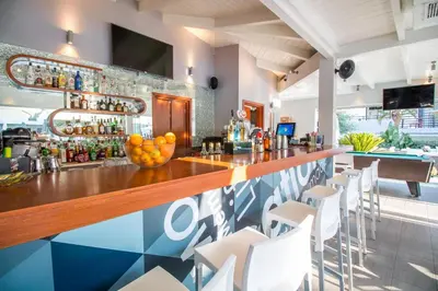 a bar in a restaurant with white chairs at Sunny Days Hotel in Ixia
