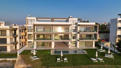 a large white building with a swimming pool and chairs at Aquarama Pool Apts. in Ixia