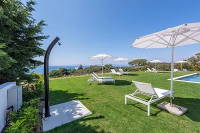 a lawn with chairs and an umbrella and a pool at Aquarama Pool Apts. in Ixia