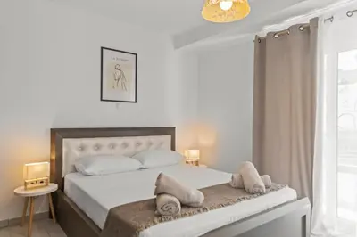 a bedroom with a bed with white sheets and pillows at Rhodian Filoxenia in Rhodes Town