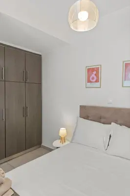 a bedroom with a large white bed and a lamp at Rhodian Filoxenia in Rhodes Town