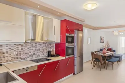 a kitchen with red cabinets and a table with chairs at Rhodian Filoxenia in Rhodes Town
