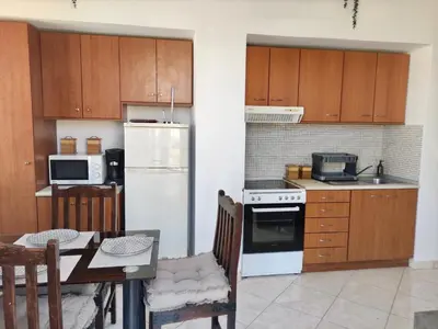 a kitchen with a table and a white refrigerator at Casa Amalia in Paradeísion