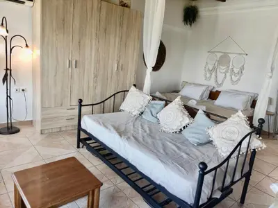 a bedroom with a bed with pillows and a table at Casa Amalia in Paradeísion