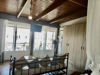 a bedroom with a bed in a room with windows at Casa Amalia in Paradeísion