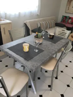 a dining room table with a gray table and chairs at Evelyn's Cozy Apartment in Rhodes Town