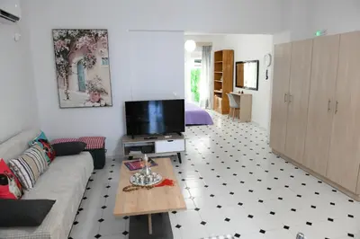 a living room with a couch and a tv at Evelyn's Cozy Apartment in Rhodes Town