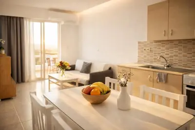 a kitchen and living room with a bowl of fruit on a table at Casa al' Tati Apartments in Ialyssos