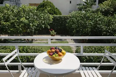a bowl of fruit on a table with two chairs at Casa al' Tati Apartments in Ialyssos
