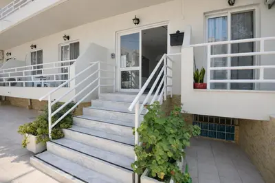 a white house with stairs and plants at Casa al' Tati Apartments in Ialyssos