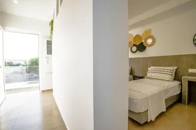 a bedroom with a bed and a mirror on the wall at Mousikorama Apartments in Faliraki