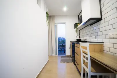 a kitchen with a counter and a table in a room at Mousikorama Apartments in Faliraki