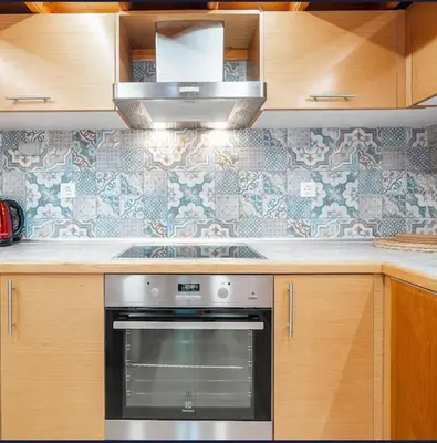 a kitchen with a stainless steel oven and wooden cabinets at Amaryllis Beach House in Lardos