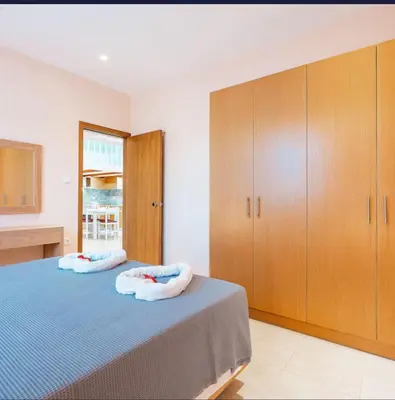 a bedroom with two beds and wooden cabinets at Amaryllis Beach House in Lardos