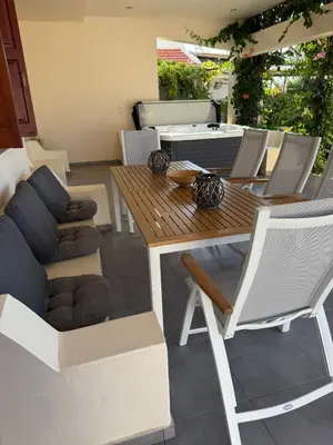 a patio with a wooden table and chairs at Amaryllis Beach House in Lardos