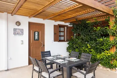 a dining room with a black table and chairs at Lindos Aeonian Villas in Líndos