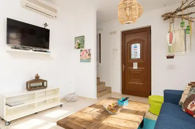 a living room with a blue couch and a table at Lindos Aeonian Villas in Líndos