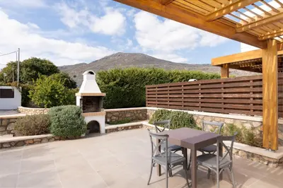 a patio with a table and chairs and a fireplace at Lindos Aeonian Villas in Líndos