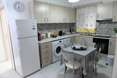 a kitchen with a table and a white refrigerator at Emerald Cozy Apartment in Rhodes Town