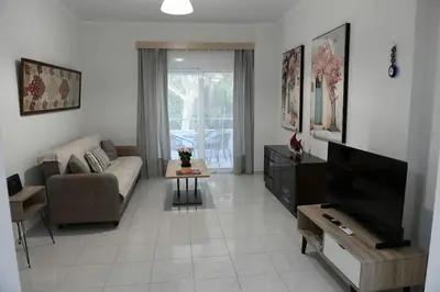 a living room with a couch and a tv at Emerald Cozy Apartment in Rhodes Town