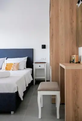 a bedroom with two beds and a table and a stool at Zen Beach House Faliraki in Faliraki