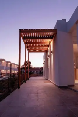 a pergola with lights on the side of a building at Zen Beach House Faliraki in Faliraki