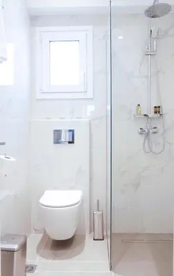 a white bathroom with a toilet and a shower at Zen Beach House Faliraki in Faliraki