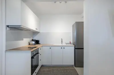 a kitchen with white cabinets and a stainless steel refrigerator at Blue Di Mare Villas in Lachania