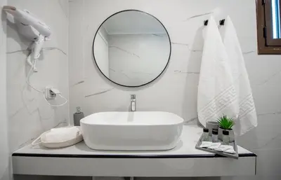 a white bathroom with a sink and a mirror at Blue Di Mare Villas in Lachania